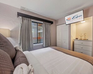 Ein Hotelzimmer mit Bett, einem Fenster mit Vorhängen, einem Kleiderschrank und einem Schild über dem Bett.