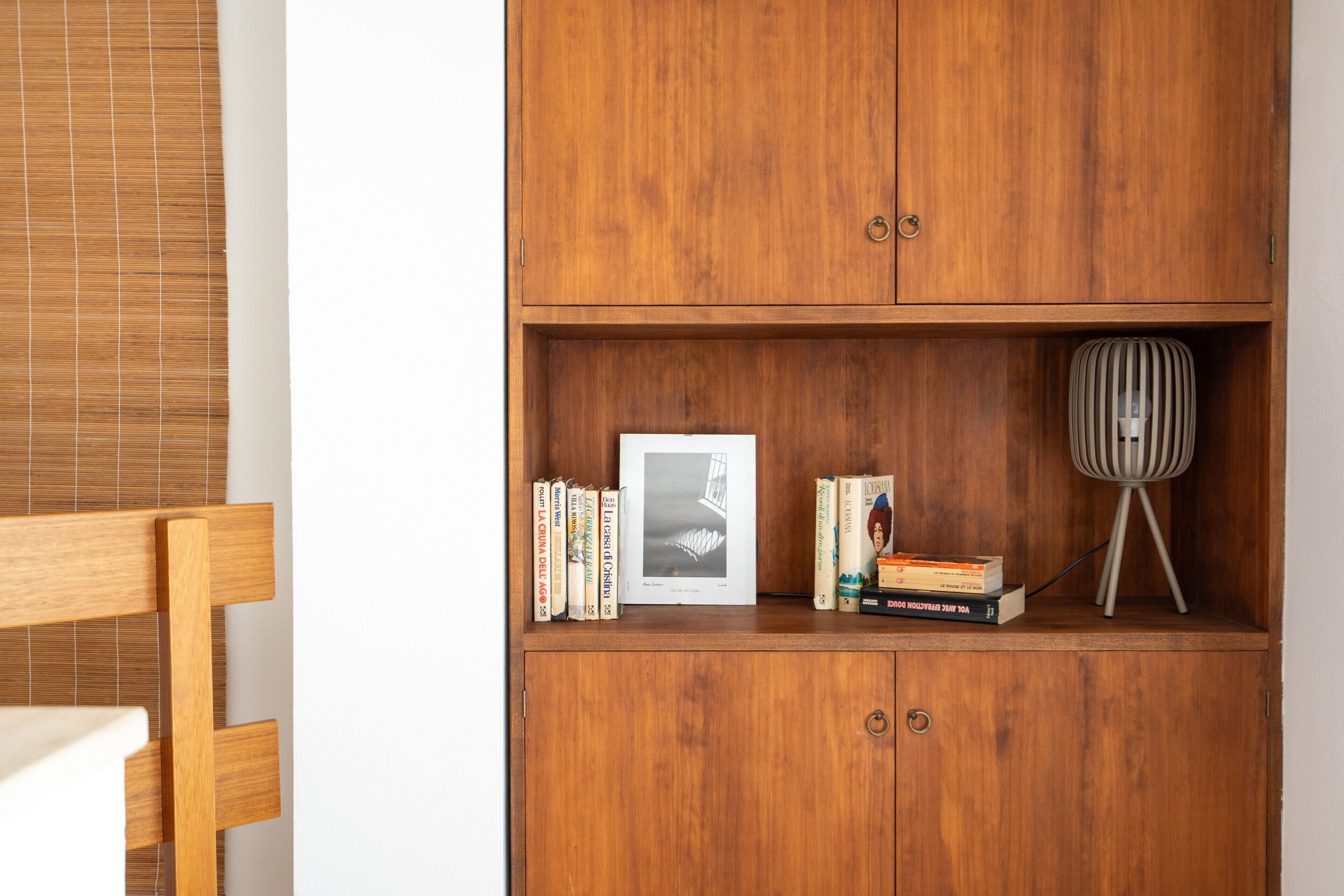 Een houten boekenkast met boeken en een ingelijste foto.
