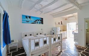 A bedroom with a bed, a nightstand, a painting, and a view of the kitchen. - Ascot Residence 2 Min Walk to the Beach (Watamu)