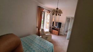 A bedroom with a bed, a TV, a chair, and a dresser. - casa giusto ischia  (Ischia)
