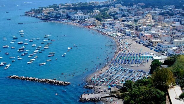 A coastal cityscape with a beach, boats, and buildings. - casa giusto ischia  (Ischia)