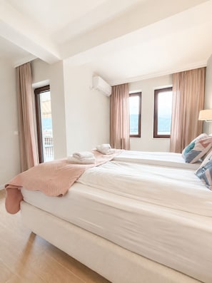 Habitació d'hotel amb un llit, una finestra i un aparell d'aire condicionat.