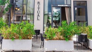 Un edificio con un cartel que dice 'RITUAL' y un diseño moderno con ventanas amplias y fachada de azulejos.