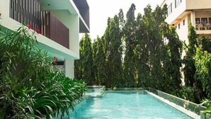Una piscina rodeada de exuberante vegetación y edificios modernos.
