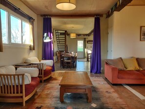 Ein Wohnzimmer mit Couch, Esstisch und Stühlen sowie einem Holztisch.