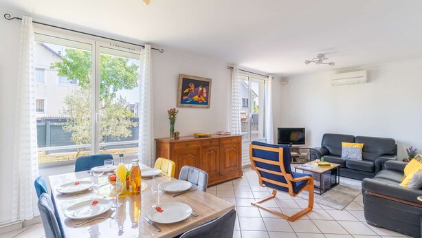 A modern living room with a dining area, a sofa, a TV, and a painting on the wall. - Entire Home · 1000m² Garden · Terrace · 30min from Paris (Conflans-Sainte-Honorine)
