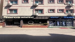 Un edificio con varias unidades de aire acondicionado, un letrero que dice 'Nares Mintel' y otro letrero que dice 'Nares Game'.