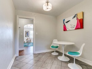A hallway with a white wall, a white ceiling light, and a door leading to another room. - Historic Crown Heights Triplex - Unit C (Oklahoma City)