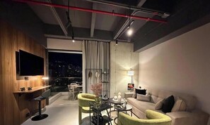 A modern living room with a sofa, chairs, a TV, and a city view. - Spectacular apartment in the town, surrounded by nature, parks and restaurants. (Medellín)