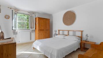 Ein Schlafzimmer mit einem Bett, einem Holzschrank, einem Nachttisch und einer runden Wanddekoration.