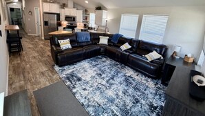 A modern living room with a sectional sofa, a coffee table, and a patterned rug.