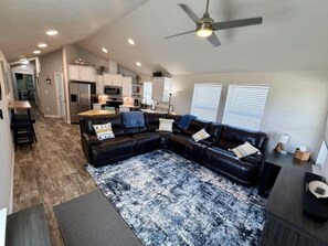 A modern living room with a sectional sofa, a coffee table, and a patterned rug. - The Bungalow – Escape, Explore, Enjoy (Garden City)