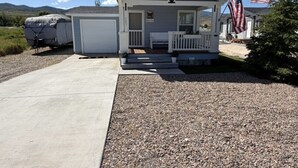 A single-story building with a porch, a garage, and an American flag.