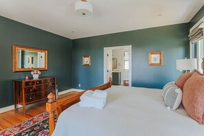 A bedroom with a large bed, wooden headboard, a dresser, and a mirror on the wall. - Forever Farm: Private Mtn Estate in Wine Country (Faber)