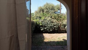 An arched doorway leading to a garden with a brick path and dense foliage.