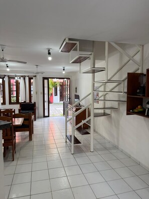 A modern interior with a staircase, dining area, and kitchen. - Nazareth ap 17 (Porto Seguro)