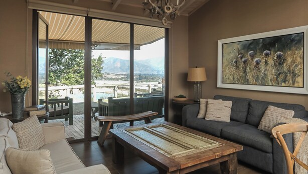 A spacious living room with a wooden ceiling, a large window offering a view of the outdoors, a sofa, a coffee table, and a painting on the wall. - Villa Fiesole 2-bedroom farmhouse in welcoming Limache perfect for relaxing (Limache)