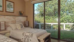 A bedroom with two beds, wooden headboard, large windows, and a view of greenery outside. - Villa Fiesole 2-bedroom farmhouse in welcoming Limache perfect for relaxing (Limache)