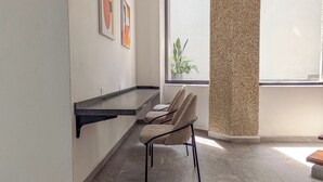 Un baño moderno con bañera, un perchero y un ventanal con vistas a un edificio.