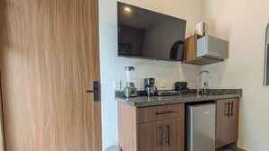 Una cocina moderna con refrigerador integrado, cafetera y licuadora.
