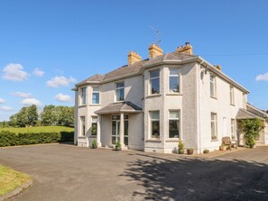 A two-story house with a driveway, multiple windows, and a chimney. - Riverdene (Omagh)