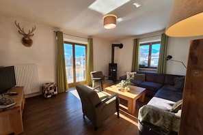 Ein Wohnzimmer mit Kamin, einer Couch, einem Couchtisch und einem Fernseher.