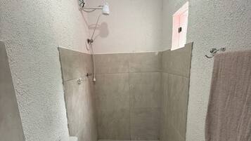 Chuveiro, toalhas de banho, papel higiênico