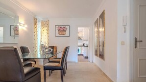 A dining area with a glass table, leather chairs, and a kitchen in the background. - Lalq13 Stunning Frontline Golf 3 bed apt (Benahavis)