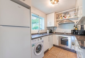 Eine moderne Küche mit Waschmaschine, Backofen und eingebauter Mikrowelle.