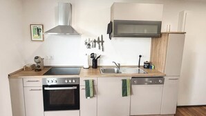 A modern kitchen with a stove, oven, sink, and microwave.