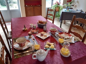 A breakfast table set with various food items, a teapot, and a coffee pot.