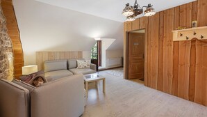 A cozy living room with a sofa, a coffee table, and a wooden wall.