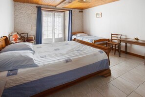 Quarto com uma cama grande, uma escrivaninha e uma cadeira.