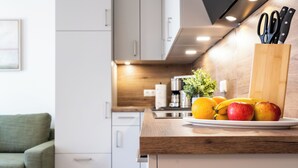 A kitchen with a wooden countertop, a coffee machine, and a fruit bowl with apples and oranges. - Dune anchor 10. balcony. Sauna. central (Grömitz)