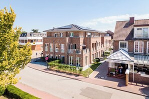 A multi-story brick building with a flat roof and a restaurant named 'Störtebeker' at the ground level. - Dünenanker 12. Infrared cabin. Roof terrace. Central location. (Grömitz)