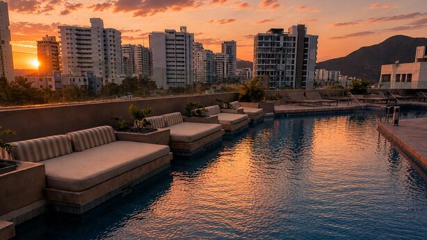 A rooftop pool with lounge seating and a cityscape view at sunset. - Premium loft with pools and jacuzzi near the beach (Gaira)
