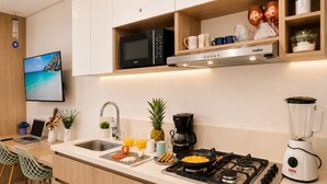 A modern kitchen with a stove, microwave, and coffee maker. - Premium loft with pools and jacuzzi near the beach (Gaira)