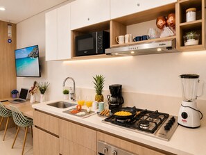 A modern kitchen with a stove, microwave, and coffee maker. - Premium loft with pools and jacuzzi near the beach (Gaira)