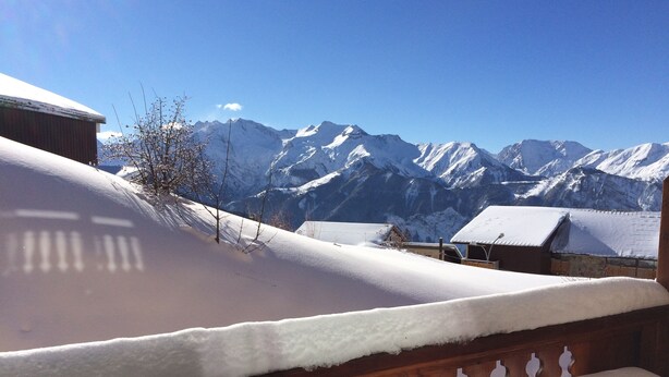 Ein mit Schnee bedeckter Balkon mit Blick auf die Berge.