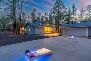 Una casa moderna con garaje, piso exterior climatizado y mesa de shuffleboard con calefacción.