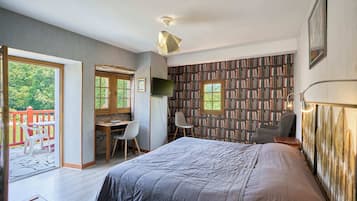 Une chambre à coucher comprenant un lit, un bureau, deux chaises, une bibliothèque et un balcon avec une rambarde rouge.
