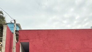 A red building with a black door and a metal basket outside. - Ideal apartment for a couple, Serra da Cantareira. (Caieiras)