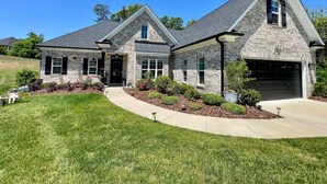 A two-story house with a garage, a front lawn, and a well-maintained garden. - Immaculate 4 Bedroom with Pool Table (High Point)