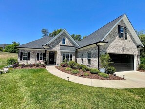 A two-story house with a garage, a front lawn, and a well-maintained garden. - Immaculate 4 Bedroom with Pool Table (High Point)