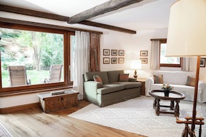 Ein gemütliches Wohnzimmer mit einer Couch, Sesseln, einem Couchtisch und einem Kamin.