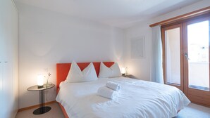 Une chambre d’hôtel avec un lit, une table de chevet, une lampe et une fenêtre.
