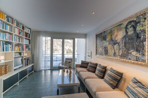 Ein Wohnzimmer mit Sofa, Couchtisch und Bücherregal.
