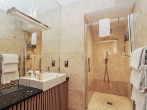 A modern bathroom with a glass-enclosed shower, a vanity with a sink, and a mirror. - Heather Island View (Oban)