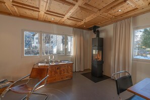 Ein modernes Interieur mit Holzboden, Kamin, Holzschrank und Essbereich.