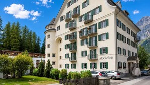A multi-story hotel with a classic European architectural style, featuring balconies and a prominent restaurant sign. - Residenza Alpenrose 19 – Stylish flat with 2 terraces & panoramic views (Sils/Segl Maria)